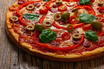 Delicious pizza served on wooden plate