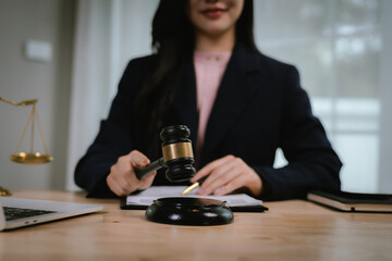 Attractive young lawyer in office Business woman and lawyers discussing contract papers with brass scale on wooden desk in office. Law, legal services, advice, Justice and real estate concept.