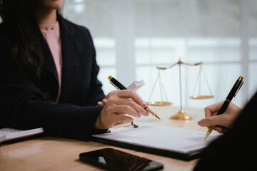 A lawyer consulting with a client in an office, reviewing legal documents and contracts related to justice, law, and business.	