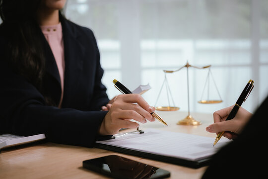 A lawyer consulting with a client in an office, reviewing legal documents and contracts related to justice, law, and business.