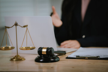 A lawyer consulting with a client in an office, reviewing legal documents and contracts related to...