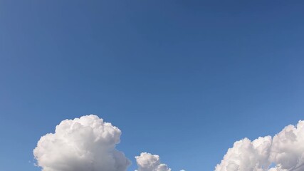 This video reveals a stunning scene with fluffy white clouds drifting across a clear blue sky. The serene atmosphere evokes feelings of calm and freedom, inviting viewers to pause and appreciate natur