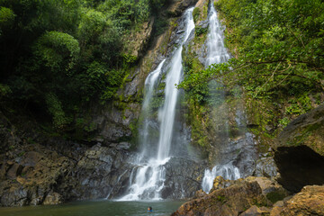 Obraz premium Waterfall in deep tropical rainforest with green rainy tree nature landscape