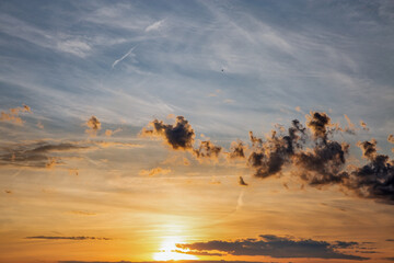 Dramatic sunset sky with scattered clouds