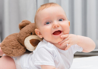 happy seven month old baby with teddy bear