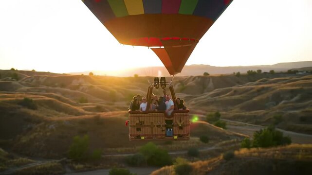 Hot air balloon soaring over golden hills at sunset, capturing a joyful group enjoying the view
