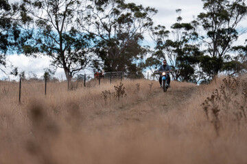 working in agriculture. girl riding a motorbike on a farm in outback Australia. Ranch worker...