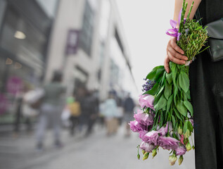A bouquet of roses in a woman's hand