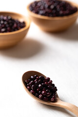 Raw Azuki beans or red mung beans in wooden spoon and bowl on white background, Food ingredient