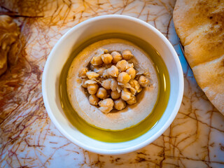 Bowl of hummus, a popular Middle Eastern dip made primarily from blended chickpeas, tahini paste, lemon juice, and garlic.