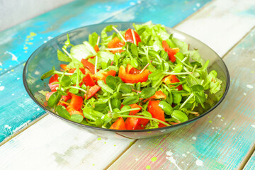 Fresh vegetable salad with micro greens and red pepper in a transparent bowl. Concept of healthy nutrition using for cookbook or food blog.