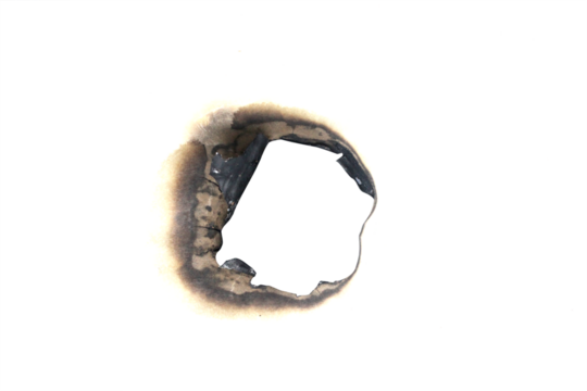 Realistic burned hole on transparent paper with scorched edges and smoke marks. Perfect for themes of fire, danger, damage, or aged effects in graphic design and digital projects.