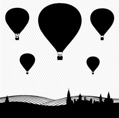 Naklejka premium Silhouette of hot air balloons soaring over a rolling landscape and distant town.