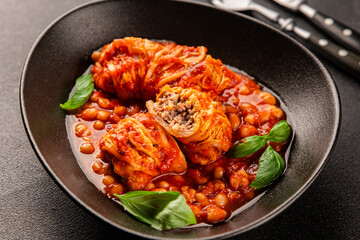 Stuffed cabbage tomato sauce with beans meat, cabbage, fresh delicious gourmet food background on the table rustic food top view copy space