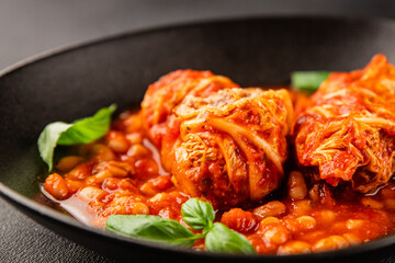 Stuffed cabbage tomato sauce with beans meat, cabbage, fresh delicious gourmet food background on the table rustic food top view copy space