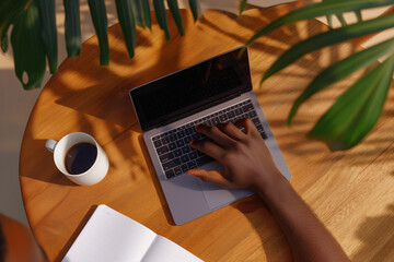 Overhead shot of hands using smartphone and laptop on a wooden desk at a coworking space, modern gadgets, notebook and coffee mug, soft shadows, top-down composition, digital lifestyle concept,