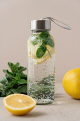 Sparkling Detox Water with Lemon and Mint in Glass Bottle. Refreshing Healthy Beverage