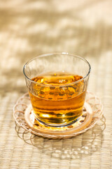 畳の上に置かれた涼しげな麦茶のグラスと茶托