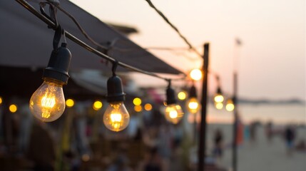 Golden sunset glow illuminating a beach restaurant with soft reflections of string lights.