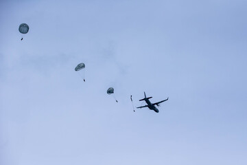 Group Parachuting Drill, Multiple paratroopers descending from the sky in synchronized formation,...