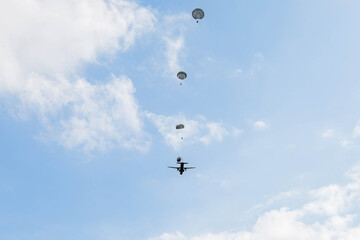 Group Parachuting Drill, Multiple paratroopers descending from the sky in synchronized formation,...