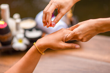 Spa Hand Soak, Relaxing foot spa treatment with herbal compresses, oils, and frangipani flowers in a serene wooden setting.
