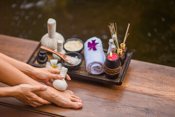 Spa Foot Soak, Relaxing foot spa treatment with herbal compresses, oils, and frangipani flowers in...