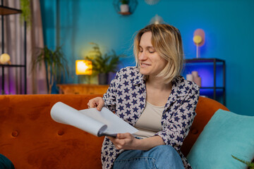 Blonde woman freelancer work with documents from home, analyzing information, read business papers...