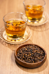 木のテーブルに並べた麦茶のグラスと焙煎大麦の粒