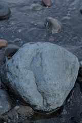 a collection of small and large stones on a beautiful beach on a sunny and cool afternoon