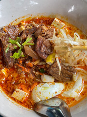 a photography of a bowl of soup with eggs and meat.