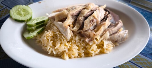 Chicken rice on a white plate in a restaurant