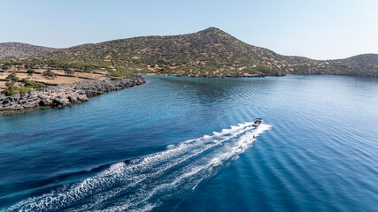 panoramic drone view of speedboat on blue water near crete island