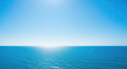 Obraz premium Tranquil ocean horizon with clear blue sky evokes peace, relaxation, and serene coastal vibes for travel, vacation, and wellness.