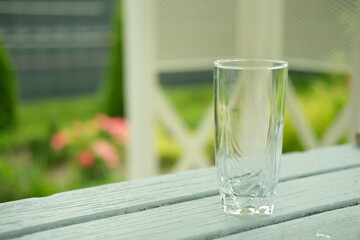 An empty transparent glass with a garden in the background