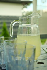 A pitcher of lemonade with a garden in the background
