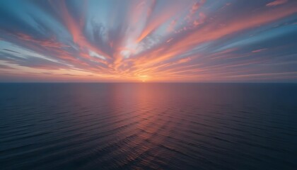 Fototapeta premium Vivid sunset over calm ocean, with streaks of pink and orange clouds