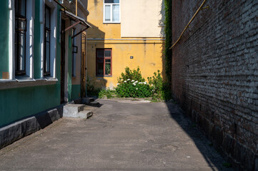 Narrow retro alley with evening shadows in yellow and green.
