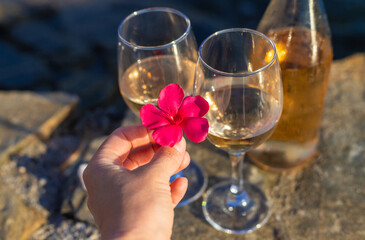 Wine in hands of woman against sea background. Selective focus.