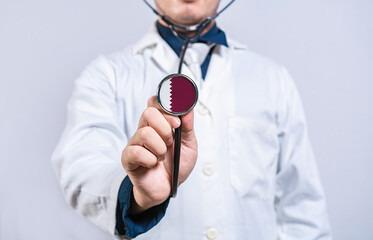 Doctor hands holding stethoscope with Qatar flag. Qatar health and care concept