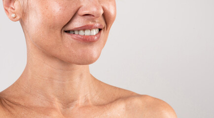 Naklejka premium Tech Neck Treatments. Cropped Shot Of Unrecognizable Middle Aged Woman With Beautiful Skin Standing Over Light Grey Background, Attractive Mature Woman Enjoying Beauty Routine, Copy Space