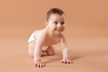 Cute little baby crawling on beige background