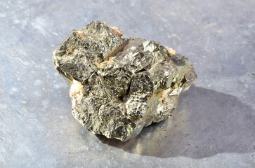 Shooting of specimen of natural mineral - pebble of pyrite (iron pyrite, fool's gold) stone isolated on background