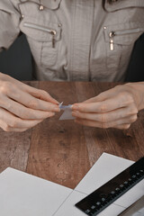 hands of an elderly woman fold origami paper. Creating an origami paper crane