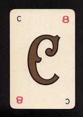 A decorative playing card featuring a letter from the English alphabet isolated on a black background.