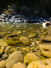 A stream running through a rocky river bed filled with rocks and moss