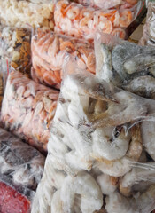Boiled and frozen shrimp in a transparent plastic bag for vacuum packaging. Selective focus