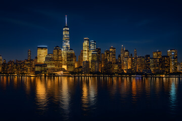 Obraz premium New york city skyline at night with lights and water reflection view