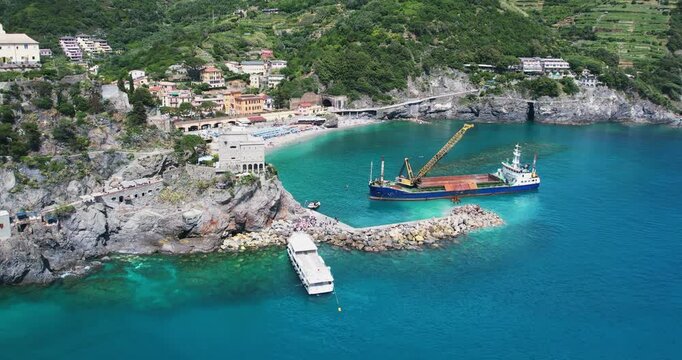 Harbor construction digger ship barge working on pier reconstruction in Monterroso al Mare in Cinque Terre, Italy