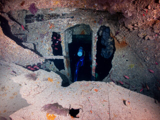 Scuba diver explores a sunken ship, SS Thistlegorm, filled with fish in total underwater silence in Red Sea